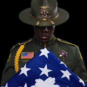 Deputy Manu Hubbard in dress uniform with folded American flag.